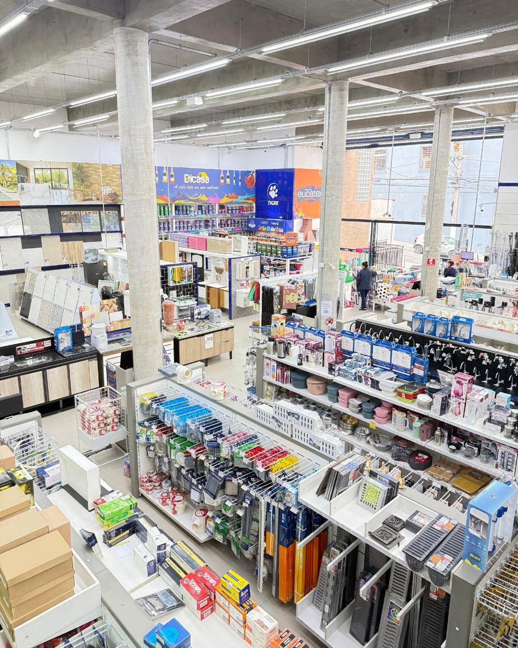 Corredor central da loja com cestos de ofertas e setor de tintas Dicasa